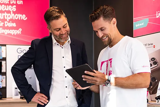 Berater und Telekom-Mitarbeiter zeigen Tablet im Smartphone-Shop, Beratung